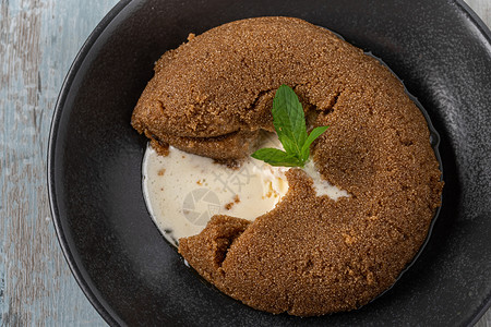 哈喽冰淇淋土耳其以黑陶瓷板上的冰淇淋在木制反面石蜡上配有Halva冰淇淋的SemolinehalvaHalva冰淇淋甜的陶瓷制品背景