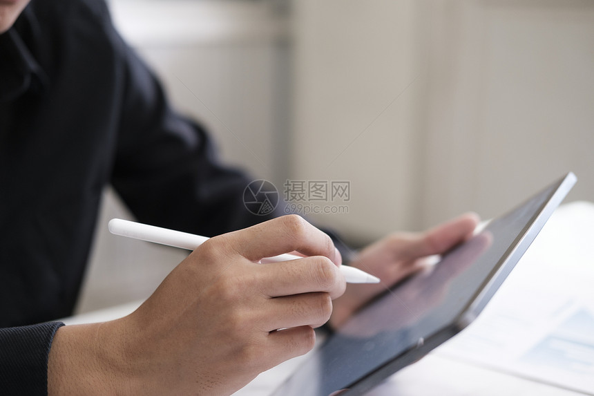 在数字笔记本上写的特质笔结人在办公室网络设计师从事无纸业务技术的项目时触摸电脑平板屏幕操作笔记本电脑分享互联网记事本图片