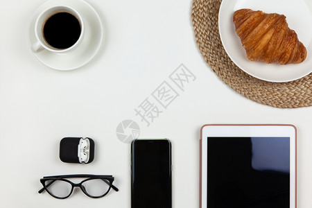 现代自由职业者智能手机咖啡平板羊角面包眼镜在白色背景情况下耳机复制空间平日业早餐在家工作呆里概念等现代工作空间休息远程办公博主背景图片