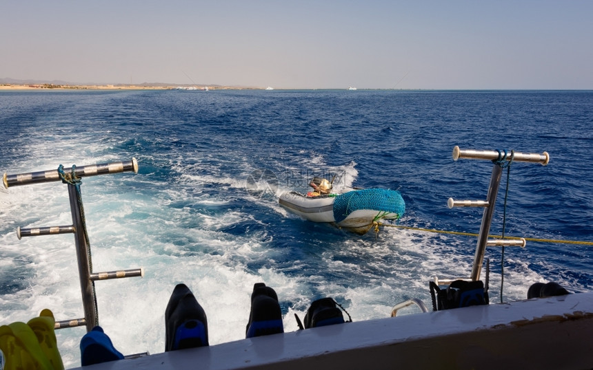 颜色在照片中一艘用快艇停靠的移动船只在前方挂起的拖鞋和防滑翔面罩以及埃背景海岸帆船导航图片