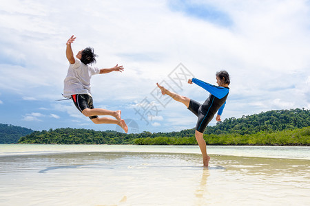 享受快乐的亚州夫妇玩活动一起好的活动女人展示了挑逗姿势踢一个男人在离科利佩岛附近的高拉维海滩上跳到远处塔里陶公园泰佐藤人们情背景图片