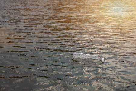 漂浮礼花碎片扫地保持近身女手握着裂土背景的透明塑料瓶这些废物来自城市和工业区无法摆脱环境设计图片