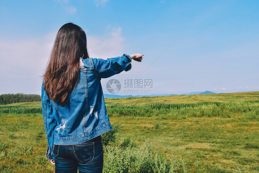 微笑清晨站在绿草地上阳光照耀的女青年以美丽的自然观景色察着绿植物田地景观对大自然的美景颜色日出图片