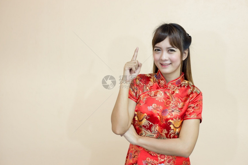 魅力泰国人们在中新年庆典幸运与手指着红金式的新年庆典亚洲妇女用传统的中文或青桑来打招呼手举欢迎的表情和幸运与手指图片