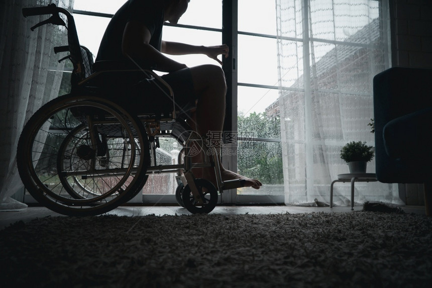 坐在轮椅上的残疾男子感到沮丧悲伤图片