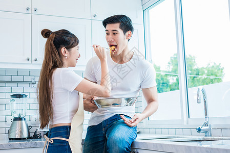 迷人的妇女作为爱或厨房的夫妻向男人提供食物蜜月和婚礼概念烹饪主题手家图片