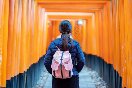 女荷官年轻女在日本亚洲京都旅游观光景点很受欢迎在日本京都游览观光景点时看着充满生机勃的橙色托里城大门程碑伏见亚洲人年轻的背景