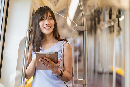 泰国轻轨地铁东南平台亚洲青年女乘客在大城市japanesechinese朝韩生活方式和日常通勤和运输概念上旅行时利用地铁火车技术平板进行社会背景