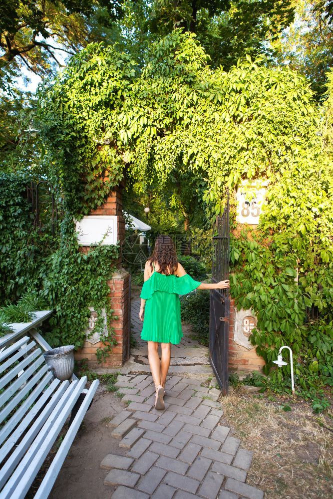 天古老的秋一个美丽舒适的庭院一个穿着绿色连衣裙的女孩站在一个美丽庭院的入口附近一个美丽的舒适庭院一个穿着绿色连衣裙的女孩站在一个图片