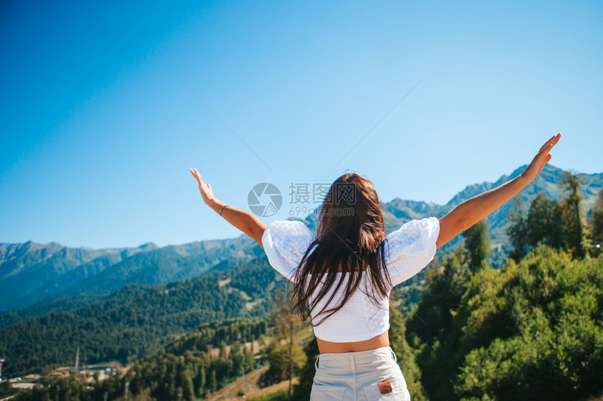 美丽快乐的年轻女子在山上度假美丽的风景快乐的年轻女子在山中雾的背景和平云徒步旅行者图片