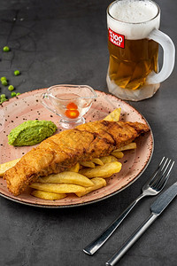 英国传统鱼和配有豆泥酱和冷啤酒的薯片海晚餐英语图片