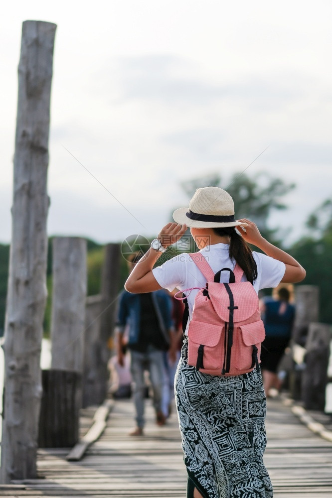 日落时年轻妇女在UBeein桥上行走亚洲旅者在缅甸阿马拉普缅甸的陆地标志附近旅行游客吸引东南亚旅游的概念很受欢迎帕努瓦木制的为了图片