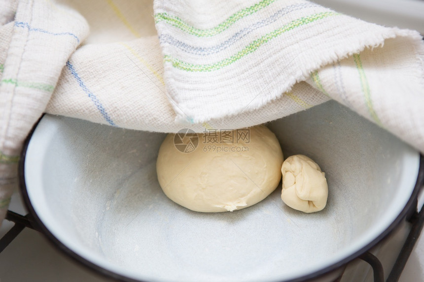 厨师准备用于制作饺子馄饨螳螂饺子的面团在毛巾下放盘子里准备用于制作饺子的面团放在毛巾下盘子里的面团高加索文化图片