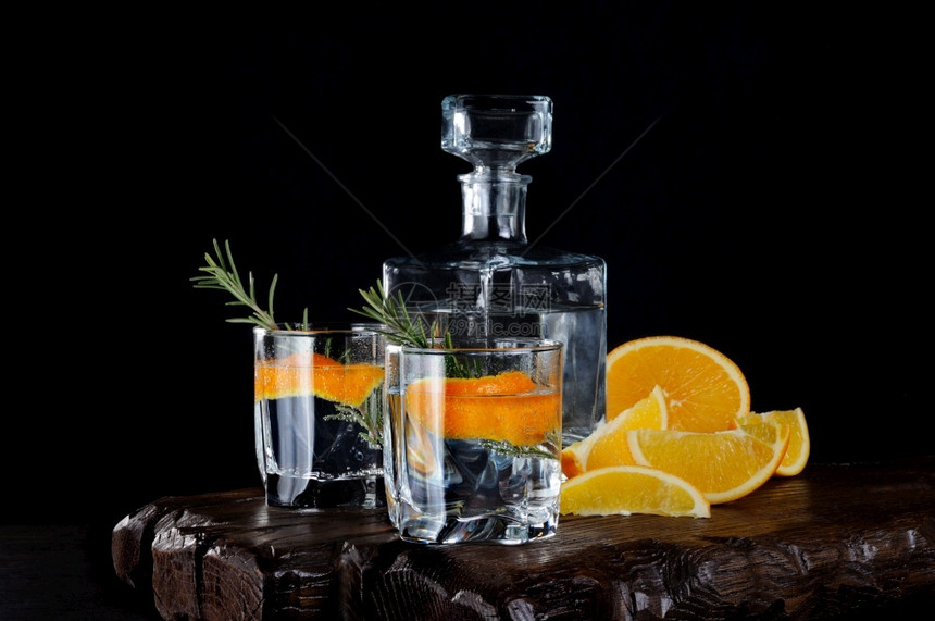 派对酒精清爽鸡尾经典干金有汤力和橙色芝士木板上有一串迷迭香切片多汁的橙子图片