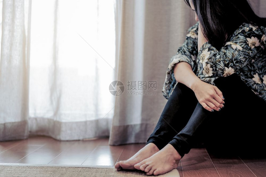 无家可归坐在客厅窗帘旁的抑郁妇女单独悲伤情绪观念独自一人依赖不高兴图片