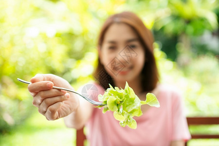 素食主义者人们蔬菜坐在花园旁边房子阳台上吃健康绿色沙拉的保健和营养食品概念她认为在家庭园圃旁边的露台里生活着一个健康的绿色沙拉高清图片