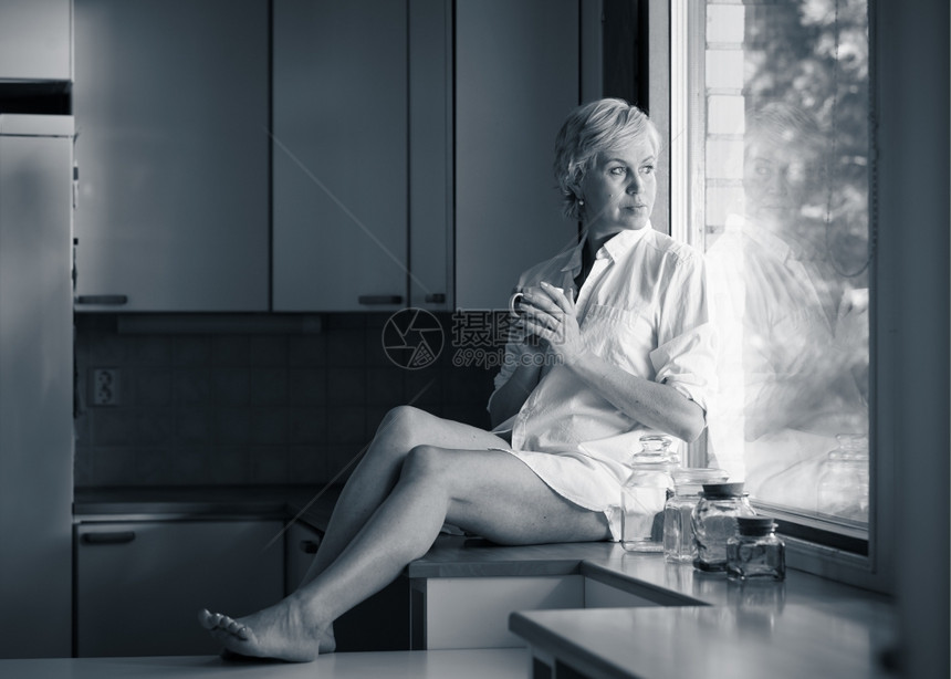蓝色的清晨成年女人在厨房喝咖啡阳光从窗外照出来自窗户的阳光快乐图片