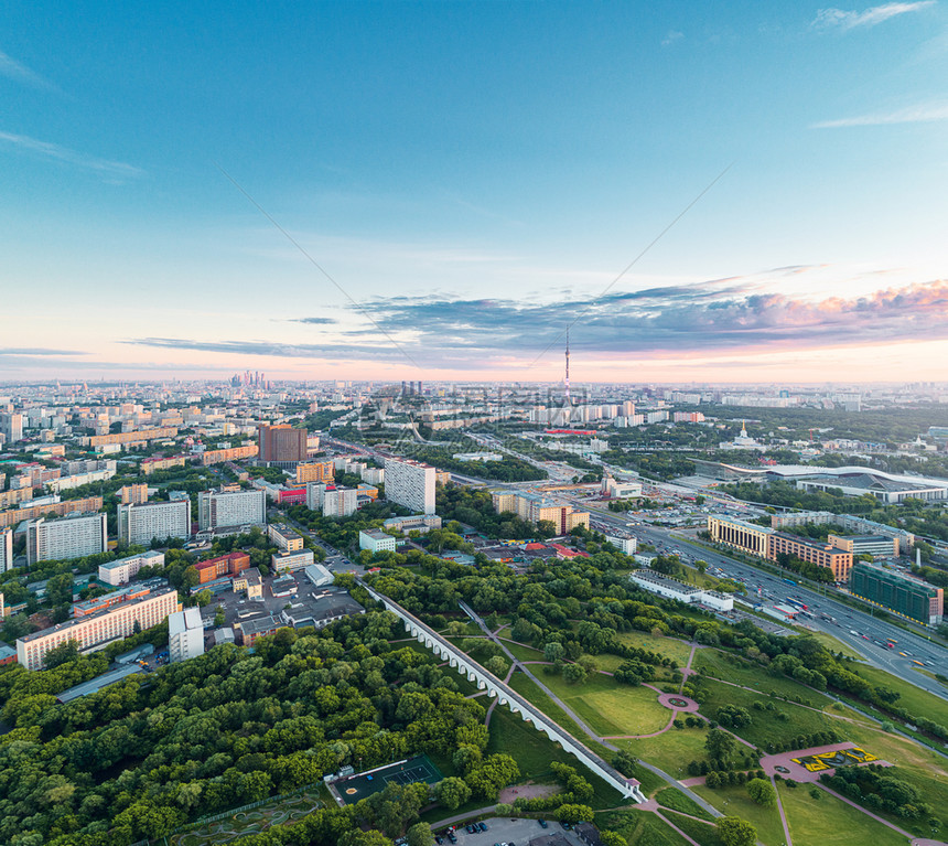 上市莫斯科在罗托基诺水龙式百万尼桥及其周围公园的空中观察夏季日落时有遥远的VDNKh公园Ostankino塔和莫斯科市商业中心摩图片