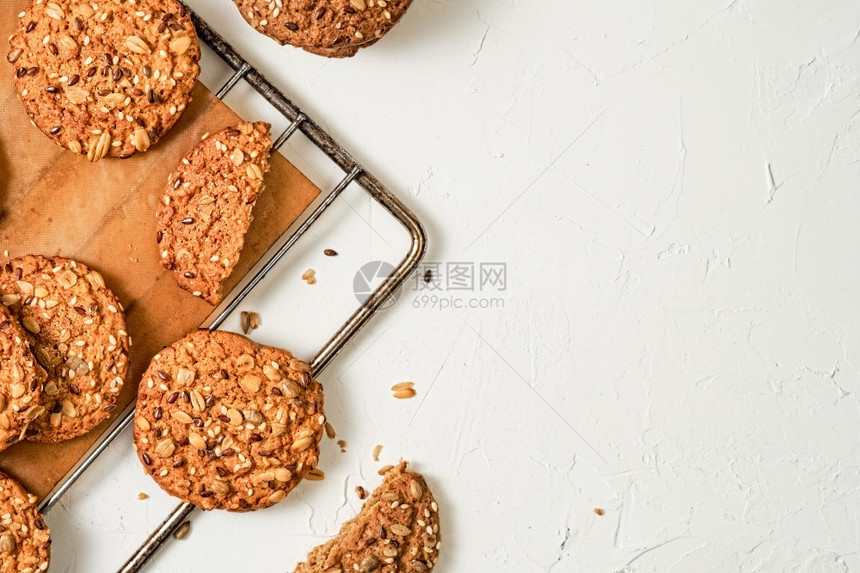 人们吃自制燕麦饼干的顶端视图在烘烤板上放有麻和芝种子白色盘与复制空间健康营养概念自制烘烤面包师图片