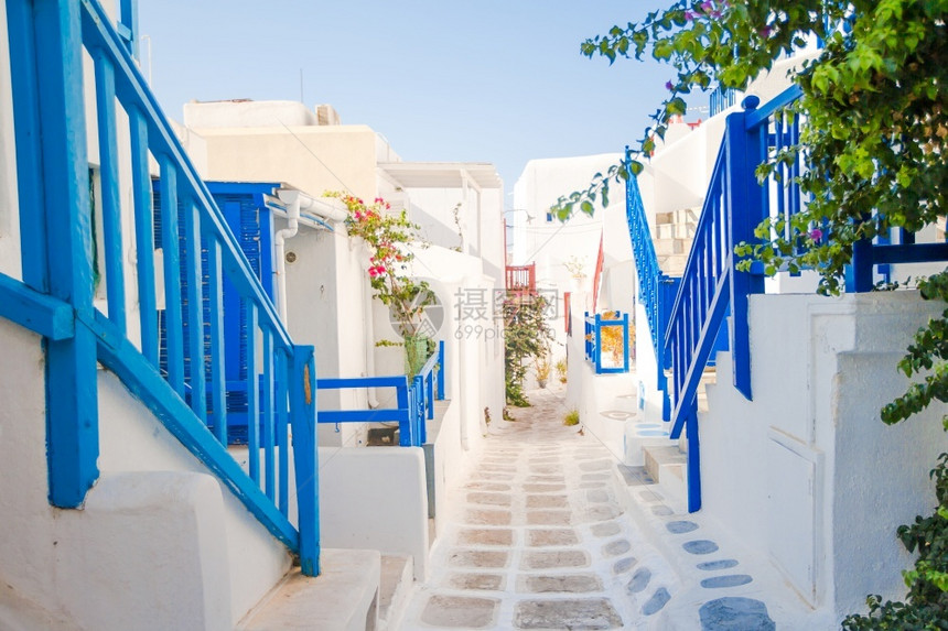 旅游户外狭窄的希腊岛街道有蓝色的阳台楼梯和花朵美丽的建筑以环形风格在外建造美丽筑狭窄的岛屿街道有蓝色的阳台楼梯和鲜花窗户图片