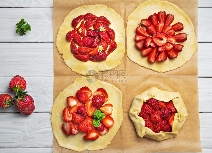制作短结糕点和新鲜草莓的薄饼平板粉烤纸上四块饼干自制糕点平坦的馅饼烘烤图片