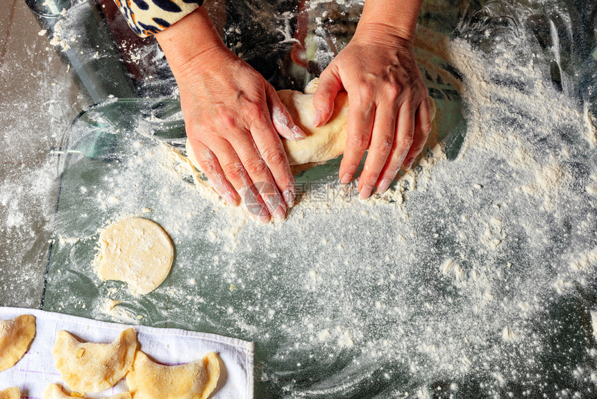 手工制作的一位妇女用手敲打面团准备美味和满意的子乌克兰烹饪缝合复制空间家庭主妇用手把面圈当做乌克兰烹饪的馅饼传统环保图片