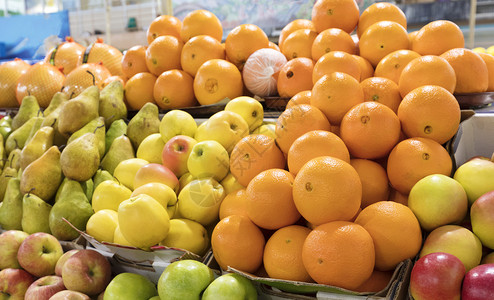 市场管销商业新鲜水果橙子苹梨的明亮背景位于市场托盘中吸引人们注意橘子梨在市场柜台出售零销背景