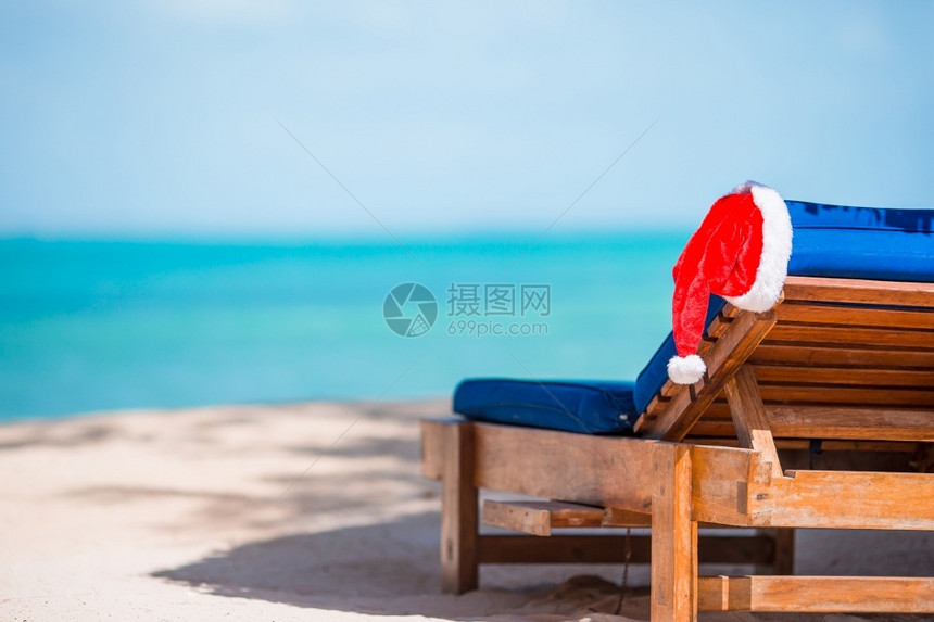 岛天堂海洋圣誕诞老人在海滩度假者身上的帽子配有松绿海水和白沙子圣诞节假期概念中圣诞假与山哈戴的太阳休闲者在美丽的热带海滩上有白色图片