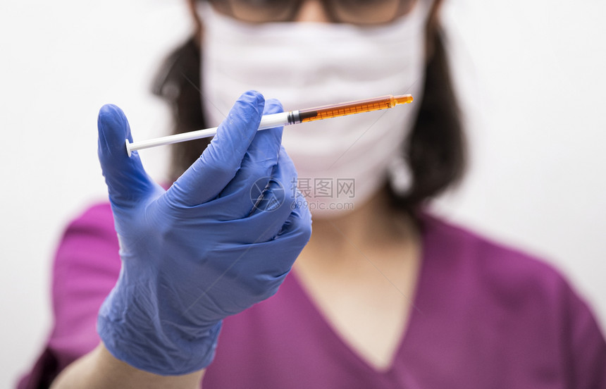 药理关心实验室持有注射器和液体疫苗的医生或护士手套式图片