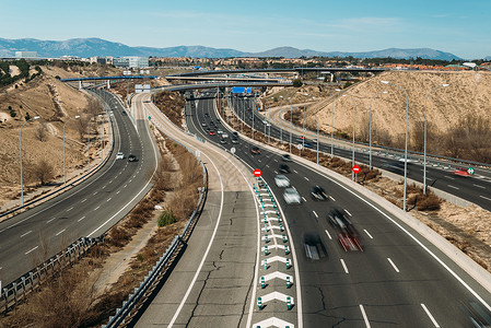 普通汽车入口匝道旅行普通高速公路立交桥与汽车长时间曝光在西班牙马德里郊区拍摄故意运动模糊普通高速公路立交桥与汽车长时间曝光在西班牙马德里背景