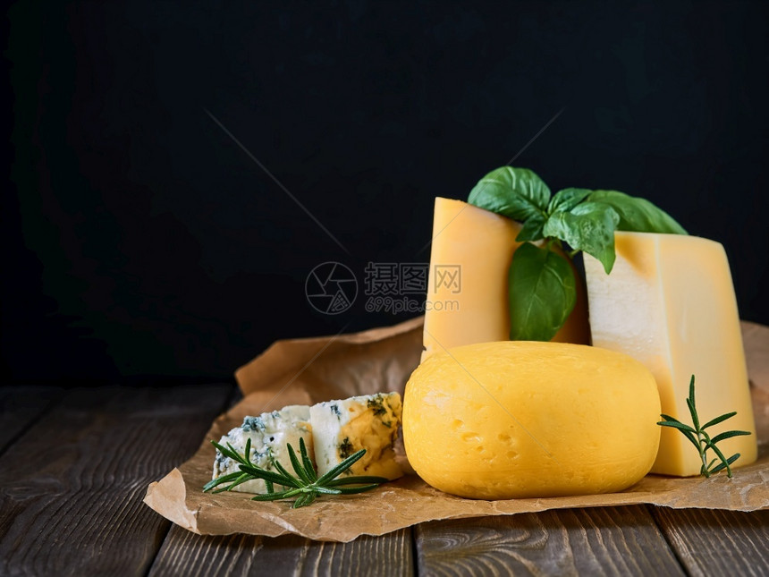 难的产品木板上各种美味的奶酪紧闭巴西和迷迭香与奶酪木桌黑底漆以及复制空间的法国和意大利手工制奶酪传统片段摄影图片