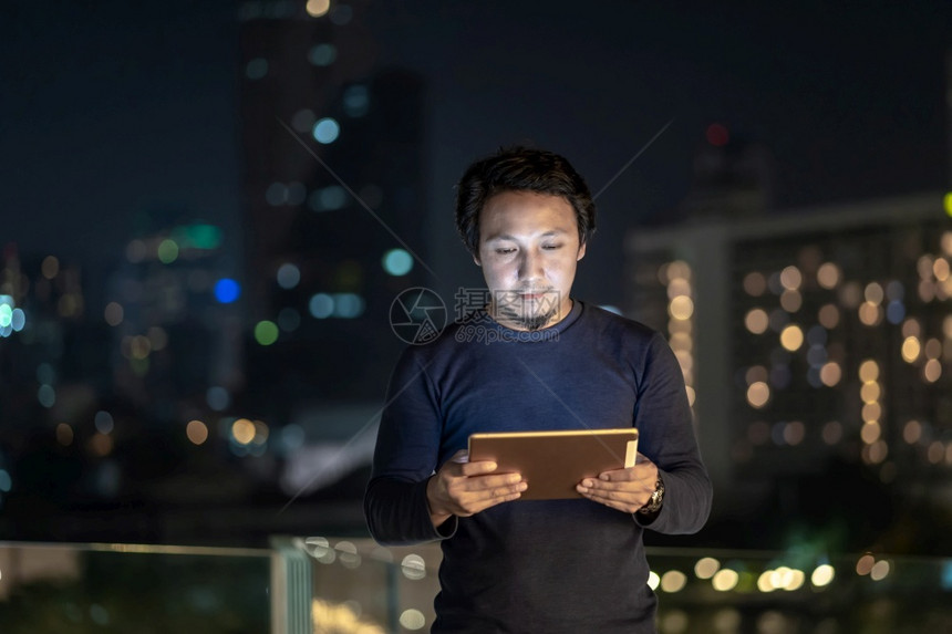 幸福在职的亚洲创意自由职业者使用技术平板机在泰国Bangkok河边金融区采取微笑行动商业技术与职概念利用技术平板机重点图片