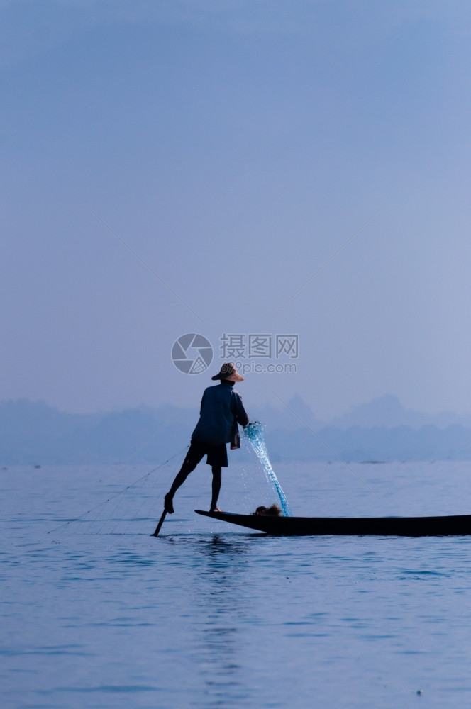 抓住农业茵莱湖的渔夫在一只脚上工作茵莱湖的渔夫在一只脚上工作缅甸渔民图片