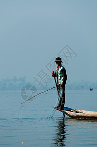 排茵莱湖的渔夫在一只脚上工作茵莱湖的渔夫在一只脚上工作缅甸生活黄昏图片