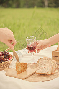 有人吗表情包食物草地有人在野餐时给另一个人送杯葡萄汁给另个在野餐中试图拿起面包吃的人吗草背景