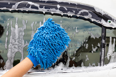 洗涤打蜡扫妇女手用蓝色微纤维织物洗脸侧面镜像现代汽车或清洁洗概念图片