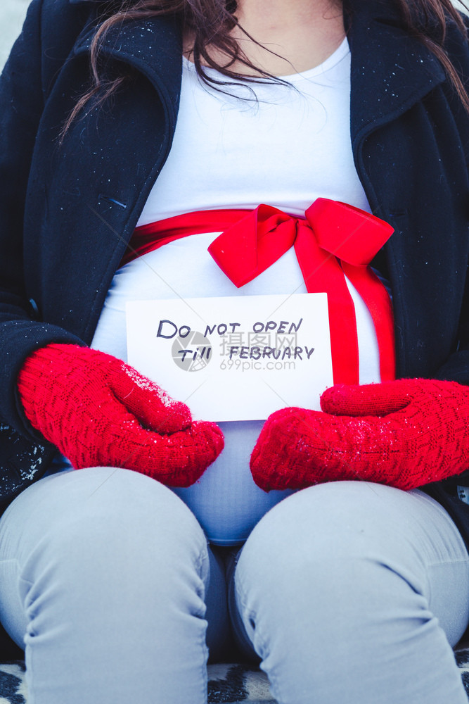 一名孕妇在冬天坐长凳上手拿着一张纸她手里拿着一张纸编号为17026关心可爱的拉脱维亚图片