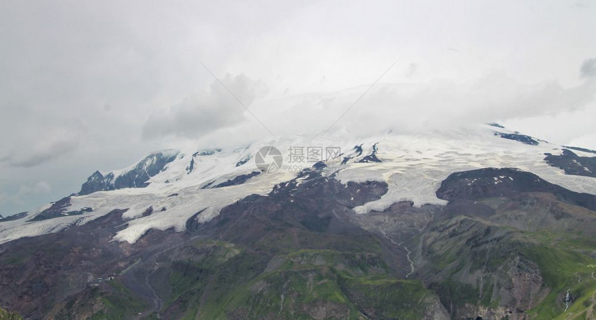 俄罗斯联邦乌古壮山北高加索地貌下雪和厚云的高加索山丘夏季日俄罗斯联邦爬坡道场景全图片