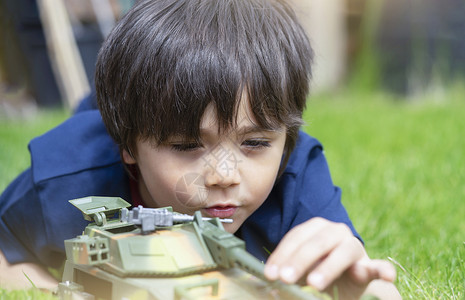 坦克游戏在户外玩玩具的小男孩背景