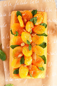 传统的糖果假期橘子蛋糕以新鲜的榨橙汁为口味用干杏仁薄荷叶和装饰图片