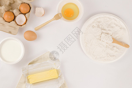 全麦面包概念一枝黄油小碗生蛋盘面粉上有木块子的粉在光线背景上酵母面包店背景图片