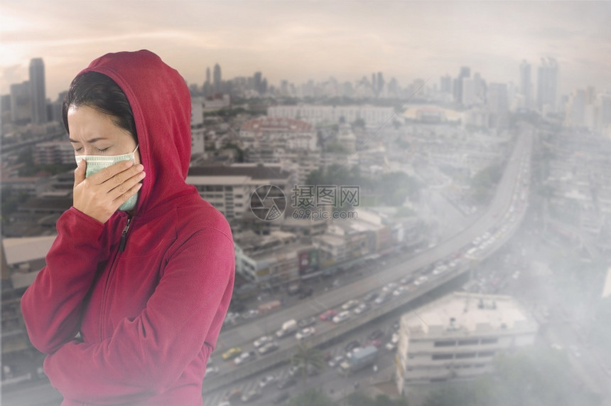 人们生病的旅行妇女有流感喷嚏妇女穿着粉红色的冬季衣着戴面罩在她的鼻子上面对曼谷市覆盖有毒尘埃的感寒冷和流健康概念身穿针粉色的冬季图片