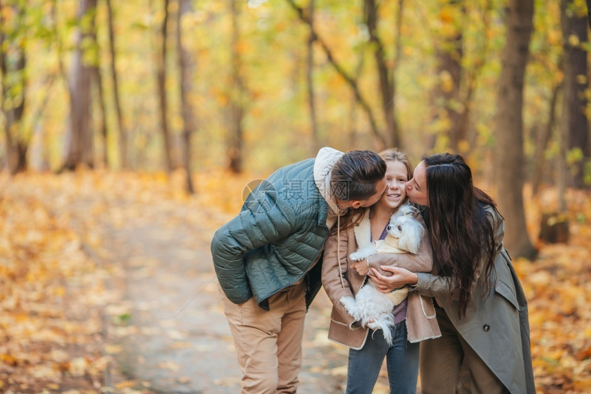 父亲育儿母吻他们的孩子秋天3岁幸福家庭的肖像秋天3个快乐家庭团结图片