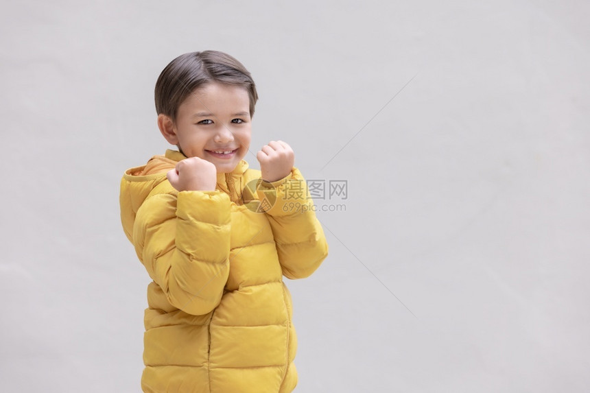 一个穿着冬服的可爱男孩黄色准备迎接即将到来的冬季节天气相机闲暇图片