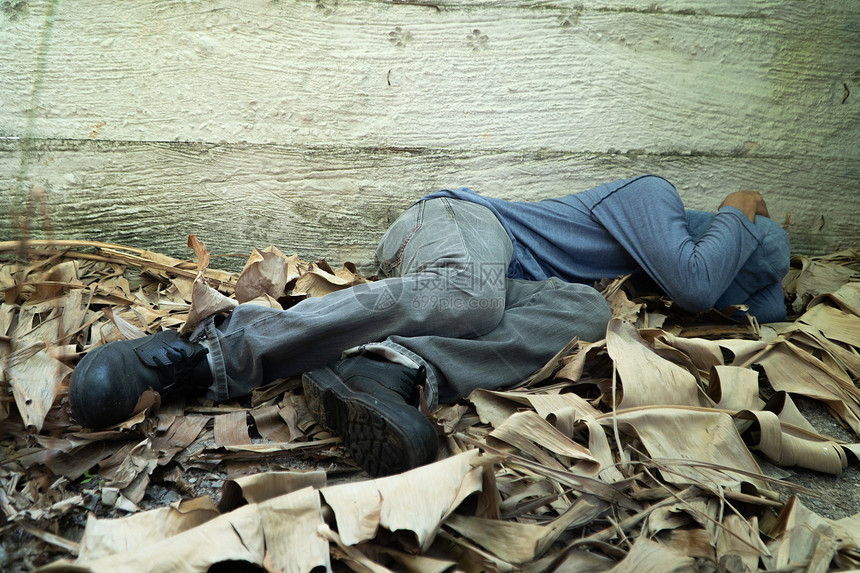 无家可归的人戴着灰色帽子和长袖衬衫因为疲惫而睡着背靠在西门子墙上坐着寒冷的女士图片