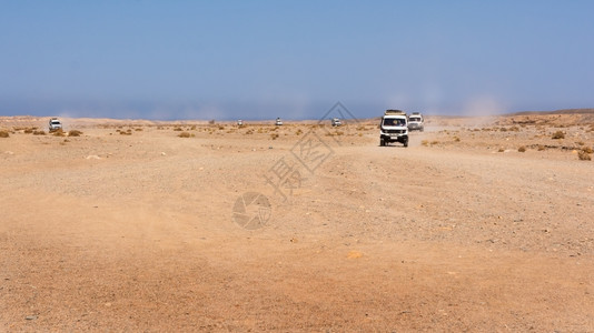 沙子的轨迹结石路埃及黑沙漠在越野车辆上移动汽橡胶的沙子上石头漠轨迹上有全景观光乌尤尼背景