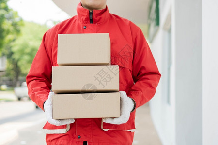 带走盒子服务邮递员站立持有三箱包裹并等待分发给客户的邮递员分包交付概念以及等待向客户分发这些包裹员工新冠背景