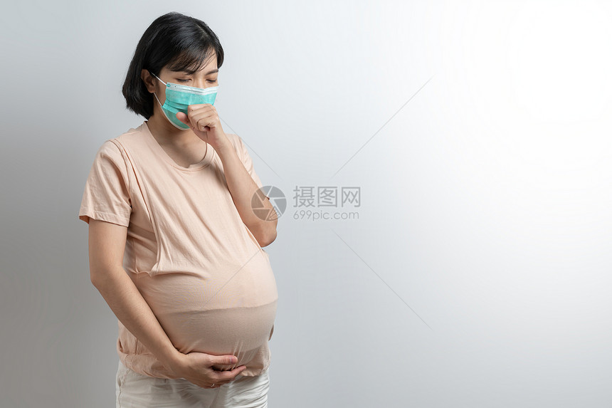感染污有冒或的年轻母亲在科幻大流行病期间用复制空触摸肚子并使用复制空间身穿保护面罩的亚洲孕妇肖像戴保护面罩在白色孤立的背景中咳嗽图片