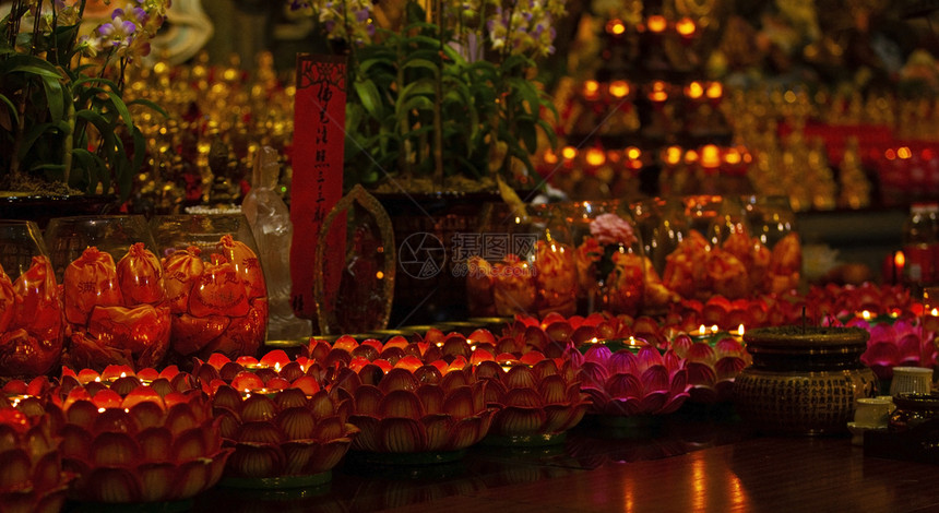 红蜡烛放在佛教寺桌上用于在寺庙里恢复生命或导航明亮的细节图片