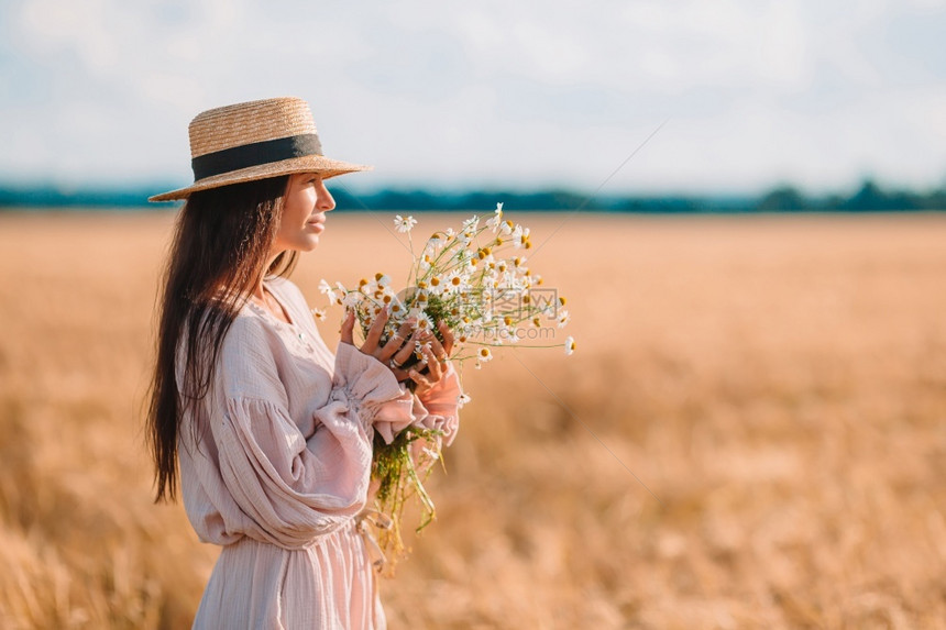 洋甘菊微笑在日落时户外美貌丽的女人后退对小麦田女孩的景色穿着草帽的漂亮美女植物图片